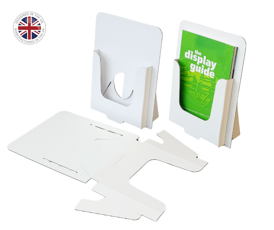 White cardboard display stand shown assembled in two upright holders and disassembled as flat panels, with a green booklet inserted into one holder. A circular Union Jack badge with the text 'British Council' appears in the top-left corner.